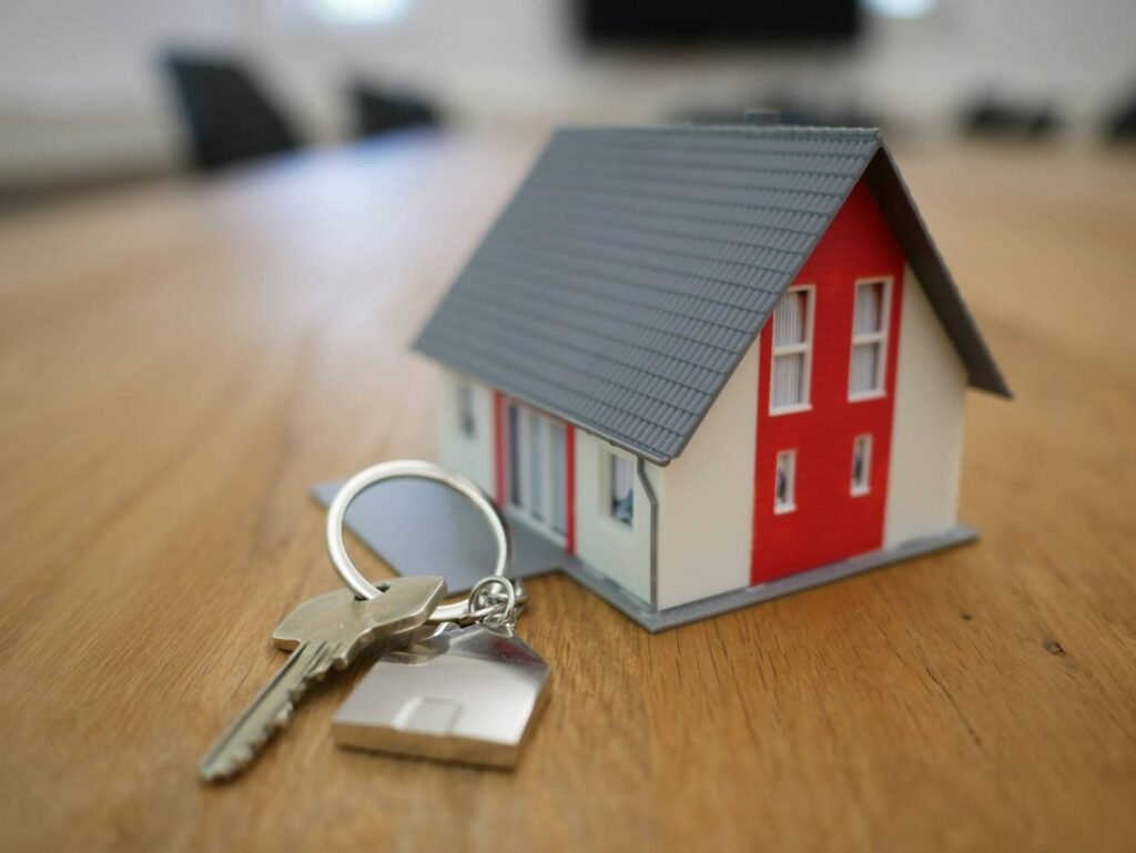 Small model house on a table representing home buying and selling decisions