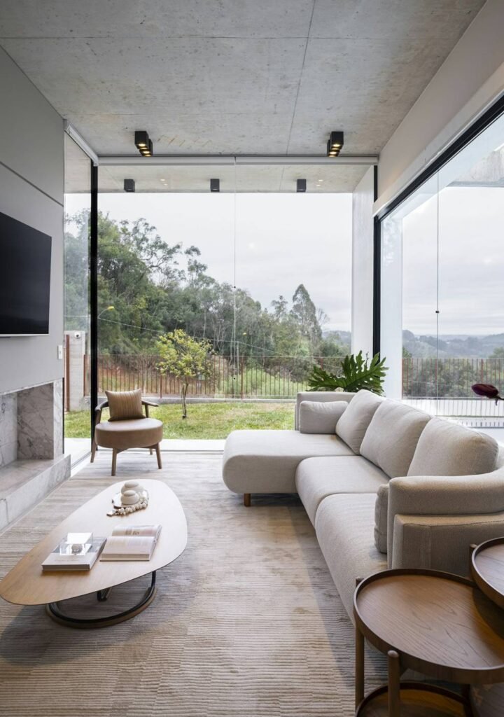Modern living room with large windows overlooking trees in an Eastside home