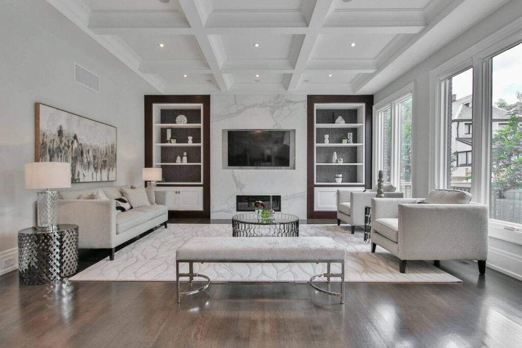 Professionally staged living room with fireplace, white sofas and built-in shelving